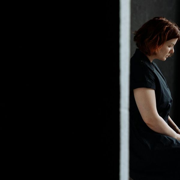 Person meditating in a quiet, minimalist environment.